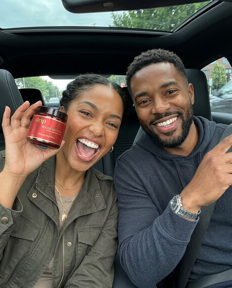 A couple laughing in the car, she holds up drip Rouge Saffron