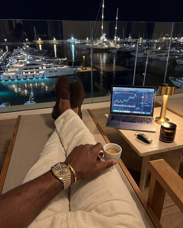 Evening on a marina balcony: loafers up, Rolex, espresso, laptop and a jar of drip Vanilla Tobacco